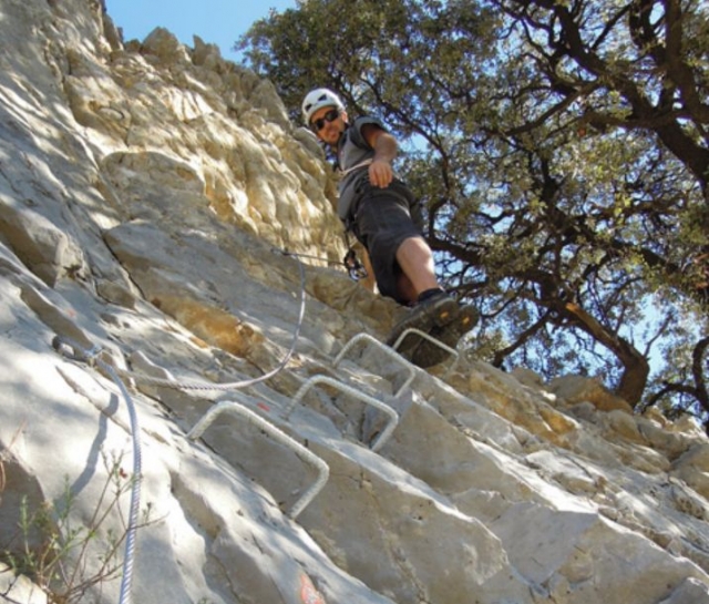 hombre practicando via ferrata en una pared vertical